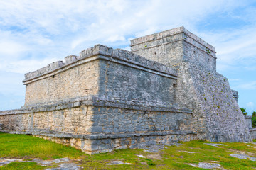 Ruins of ancient Tulum. Architecture of ancient maya. View with temple and other old buildings, houses. Blue sky and lush greenery of nature. travel photo. Wallpaper or background. Yucatan. Mexico.