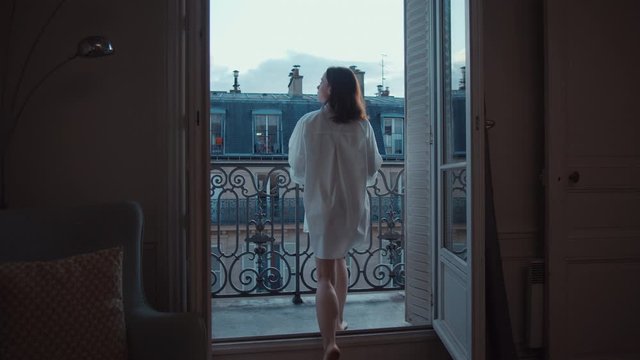 Young girl running to open balcony with a view of Paris