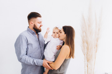 Happy young family in a bright studio. Full family.