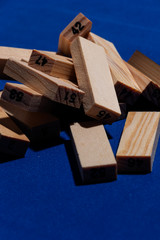 Pila de Bloques de madera sobre mesa en color azul clásico con luz dura y sombras marcadas y los...
