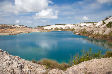 Turquoise beautiful lake formed after mining bauxite in subtropical forests on a clear Sunny day. Nature, ecology, and environmental protection.