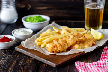 Fish and chips on a wooden background. British fast food. Recipes. Snack to beer. English cuisine.