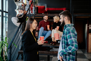 Break time in a modern office center charismatic and multiethnic workers drinking some fresh coffee and socializing with each other and smiling