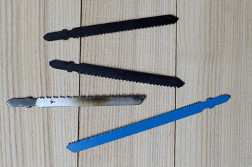 jigsaw blades on a wooden surface. Top view.