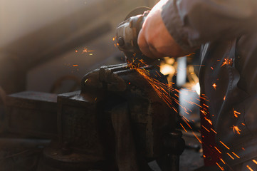 sawing metal. sparks frying over the working table during metal grinding