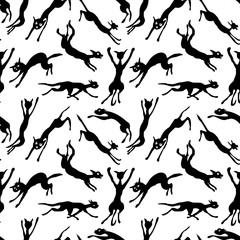 Seamless background of silhouettes jumping and running cats