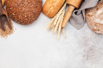 Various bread with wheat and cooking utensils