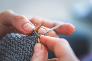 Knitting at home: Close up of wool, thread and female fingers