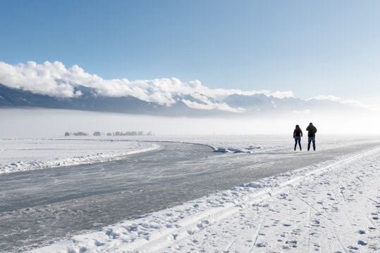 Ice Skating And Ice Fishing In The Fog On Lake Windermere At Invermere, British Columbia, Canada