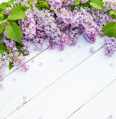 Obraz premium Bouquet of purple lilacs flowers on a light blue shabby wooden background. Vintage floral background with spring flowers. Copy space