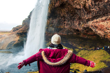 Woman enjoying visiting a waterfall view in Iceland