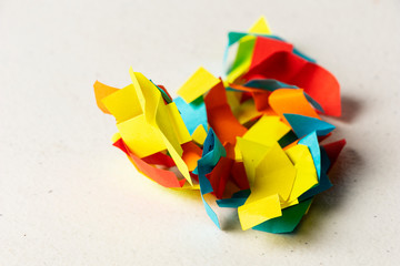 Trocitos de papel de colores arrugados en una bola sobre un escritorio blanco con ideas desechadas