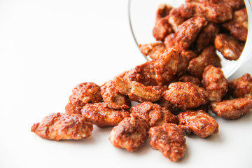 Sugar roasted pecan nuts (caramelized, praline nuts) in a glass on a white background, back view