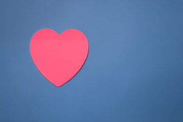 Fototapeta na wymiar Handmade pink heart on a blue surface with copy space