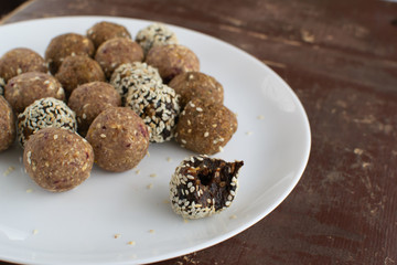 Energy balls of oatmeal with nuts, dates, pumpkin seeds, cranberries, prunes and tangerines. Horizontal orientation.