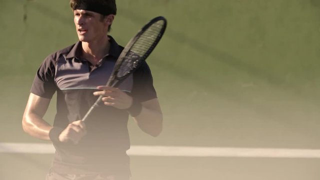 Professional tennis player hitting forehands and gets disappointed after losing a rally in match. Young man playing tennis on hard court.