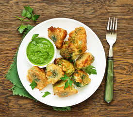 Fried broccoli in batter with green sauce. Selective focus