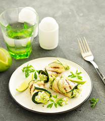 Zucchini rolls stuffed with cottage cheese and avocado. Snack. Selective focus.