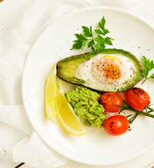 Fried eggs in avocado with guacamole sauce. Breakfast. Selective focus