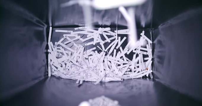 Waste paper basket filling with bits of shredded office paper