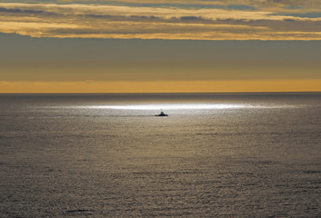 Fishing boat in the sunburst spotlight at sea