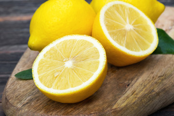 Obraz na płótnie Canvas ripe sliced lemon fruits on wooden board
