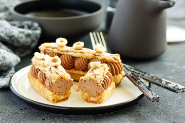 Homemade eclair with chocolate and nuts. Pastry.