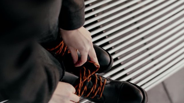 Close up view of woman fashion leather black boots walking posing in the evening street. Fashion footwear.