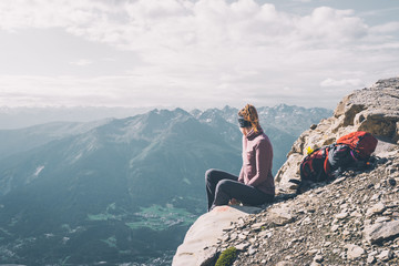 Wanderin schaut auf eine idylische Alpenlandschaft in die Ferne