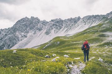 Frau wandert auf einem idylischen Weg in den Alpen
