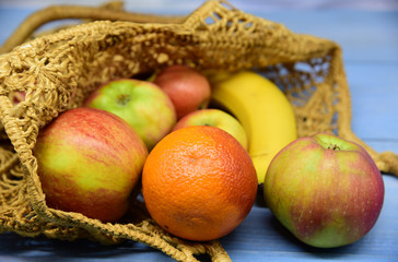 Various fresh fruits in a woven bag made of environmentally friendly material.