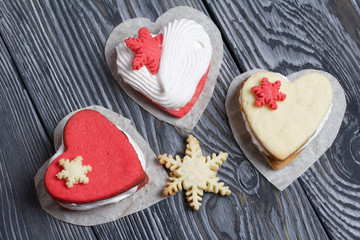 Marshmallow sandwiches decorated with cookies in the shape of a snowflake. On brushed pine boards painted in black and white.
