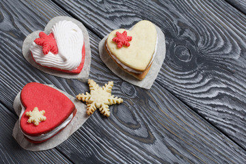 Marshmallow sandwiches decorated with cookies in the shape of a snowflake. On brushed pine boards painted in black and white.