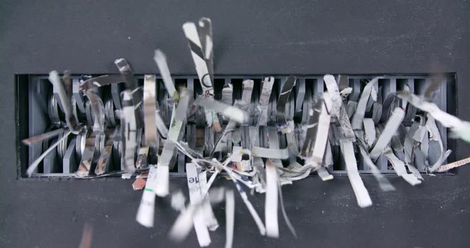 Close shot of paper being shredded through mechanical jaws