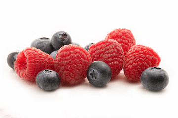 Blueberries and raspberries isolated against white