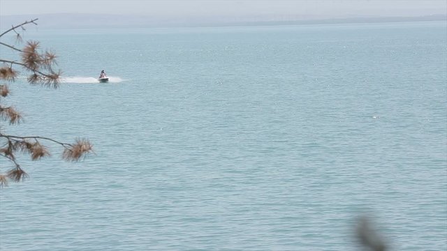 Riding a scooter in Lake Sevan (Armenia). Tricks with a scooter in the water. Beautiful footage of the beach and trees. Shoot on 10 August 2019.