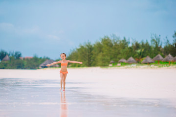 Fototapeta premium Happy little girl walking at beach during caribbean vacation