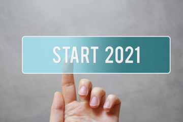 Finger pressing blue transparent start 2021 button on virtual interface on gray background with copy space for text. Concept of new year.