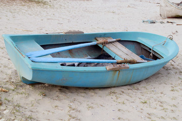 Fototapeta na wymiar blue boat stands on the sand by the sea