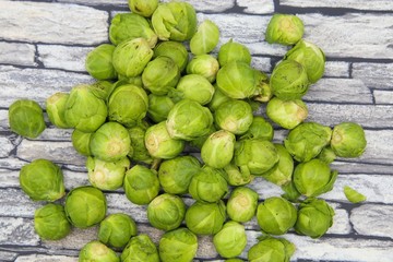 Close up of pile green raw fresh brussels sprouts (brassica oleracea), grey stone background