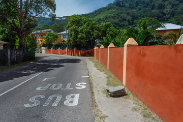 Bus stop sign on the road, bus stop in exotic country, seychelles bus stop written on the road in white