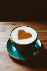 Cup of cappuccino coffee decorated cinnamon heart symbol. The concept of Valentine's day and morning.