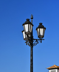 Fototapeta na wymiar Antigua farola en una calle de Villa Real do Santo Antonio en Portugal