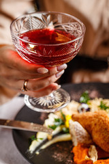Modern Ukrainian, European cuisine. The girl eats a meatball in Kiev and drinks red wine in a restaurant. In the hands of a knife and fork. background image, copy space text