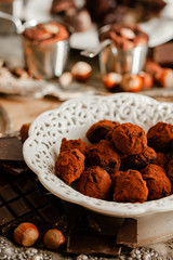 Homemade delicious dark chocolate  truffles. Served in white vintage plate, sprinkled with cocoa powder. Delicious elegant dessert for sweet-tooth. Romantic atmosphere. Close up, macro