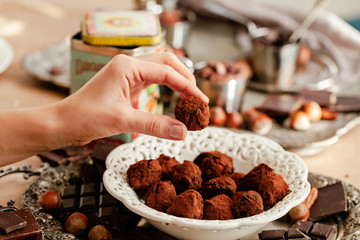 Homemade delicious dark chocolate  truffles. Served in white vintage plate, sprinkled with cocoa...