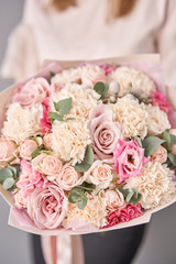 European floral shop. Beautiful bouquet of mixed flowers in womans hands. the work of the florist at a flower shop. Delivery fresh cut flower.