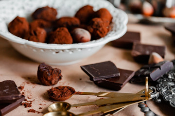 Homemade delicious dark chocolate  truffles. Served in white vintage plate, sprinkled with cocoa powder. Delicious elegant dessert for sweet-tooth. Romantic atmosphere. Close up, macro