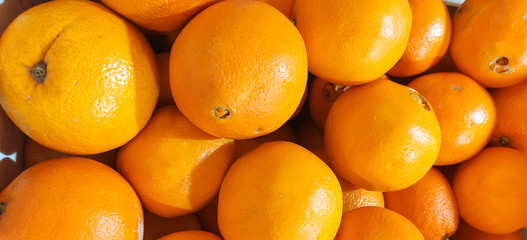 Orange citrus.Ripe, fresh, yellow oranges in baskets are sold in the grocery store market, fruits and vegetables. Lots of oranges. Food background.