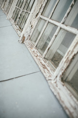 Old abandoned window frame with cracked white paint and clear glass. Selective focus macro shot with shallow DOF